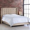 Upholstered bed with wing back headboard.