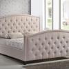 Fully upholstered bed with button tufting and nail heads with border. 
